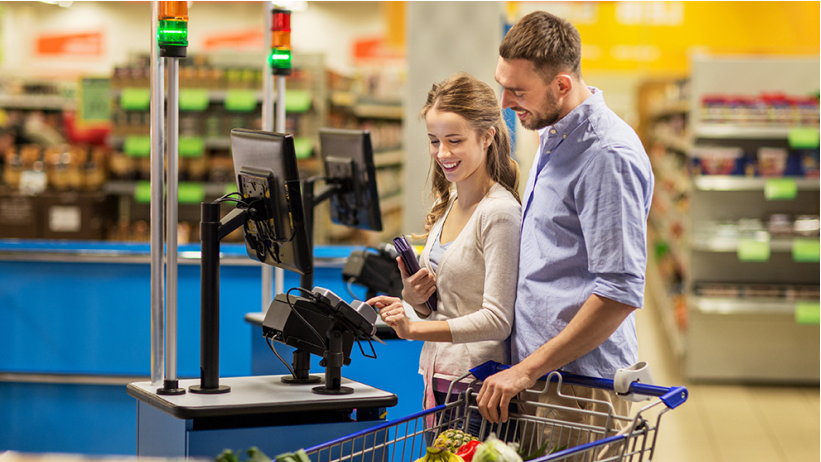 Pessoas passando os produtos no leitor de codigo de barras